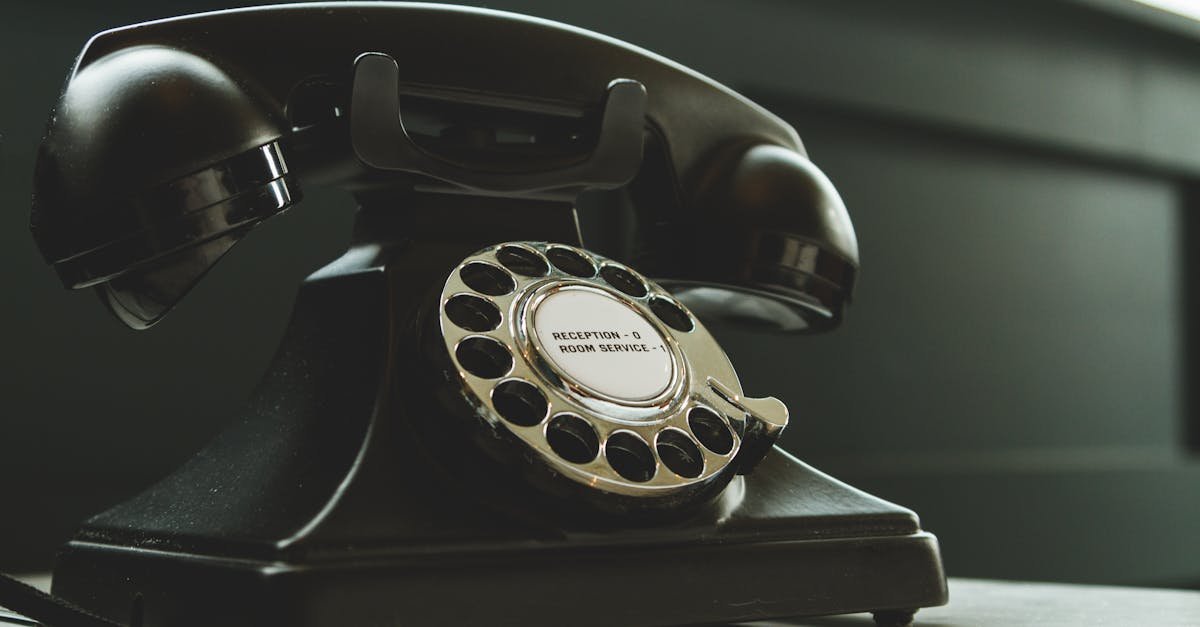 Classic black rotary phone on hotel reception desk, evoking nostalgia and vintage charm.